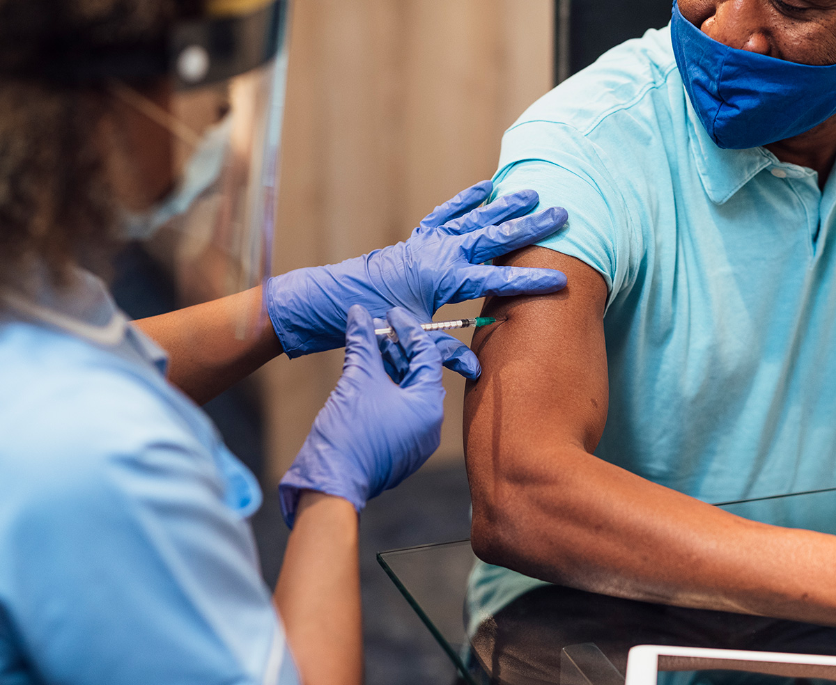 medical professional administering a shot to patient