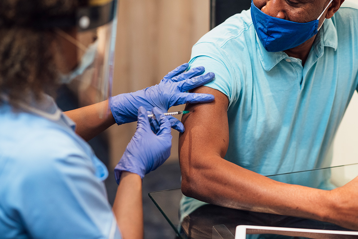 medical professional administering a shot to patient