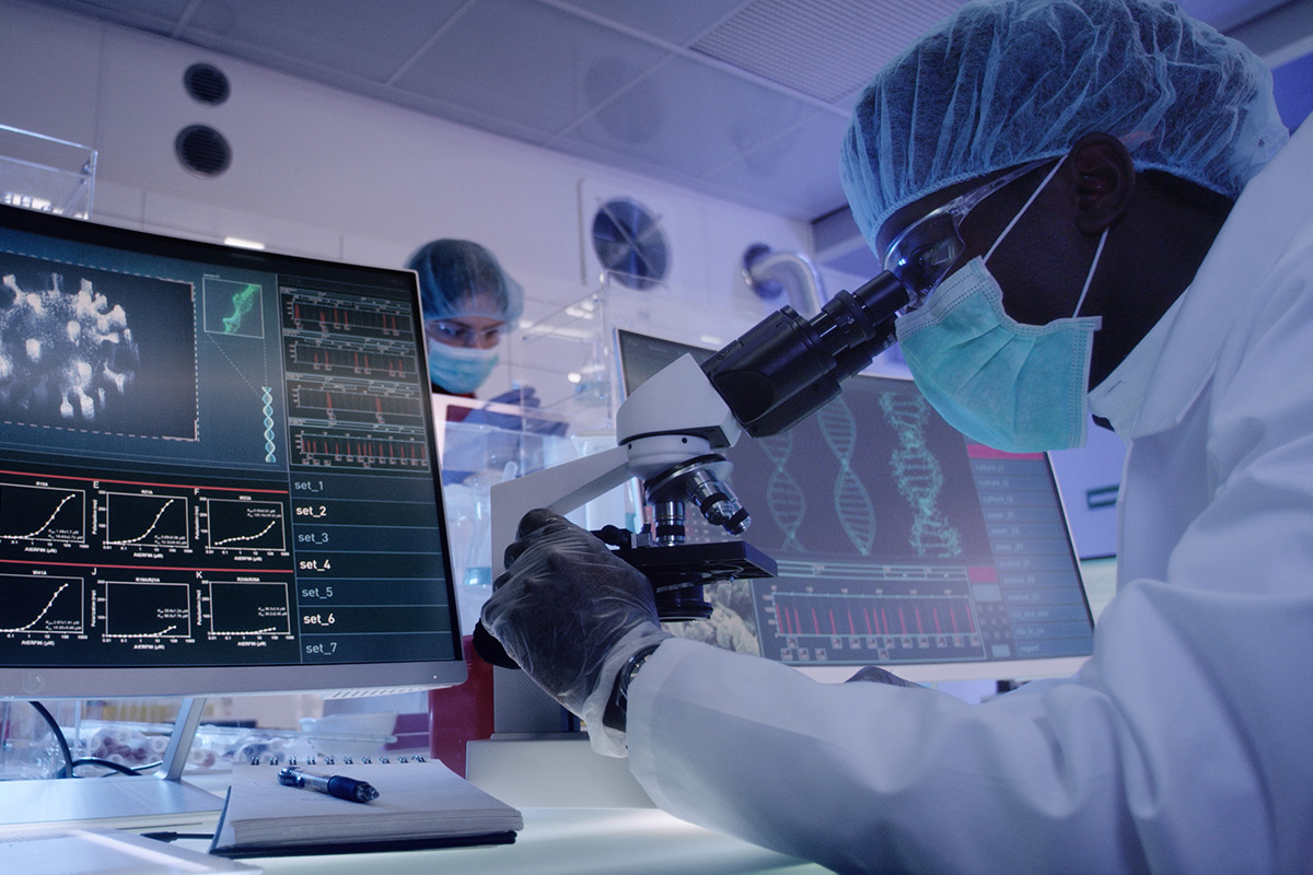 medical lab with health professional looking through microscope