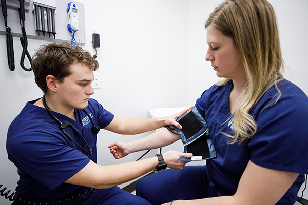 A medical student checking the blood pressure of a patient.