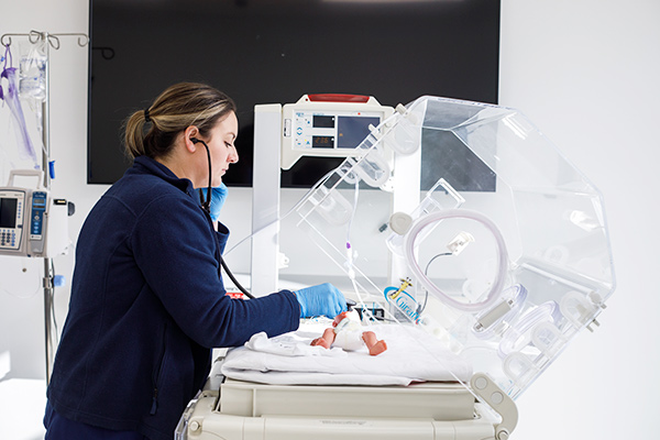 Medical student working with a baby in a hospital setting