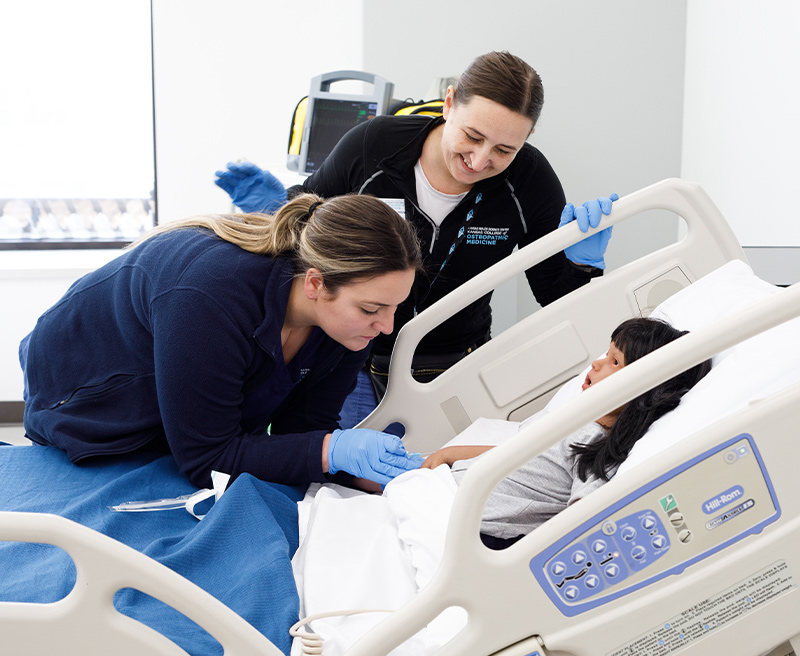 A medical student working on a child dummy.