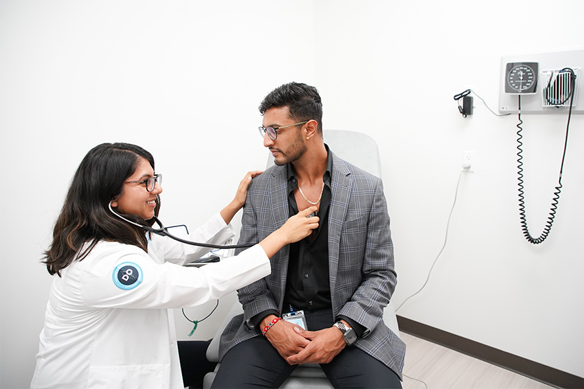 A DO student checking a patients heartbeat