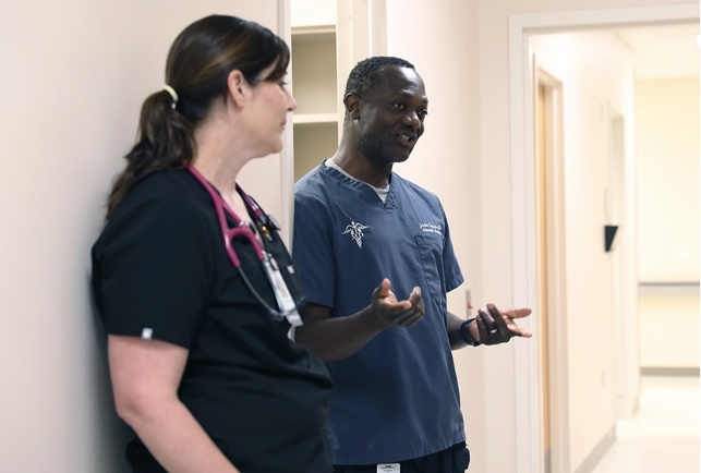 two medical professional with stethoscopes around their necks talking